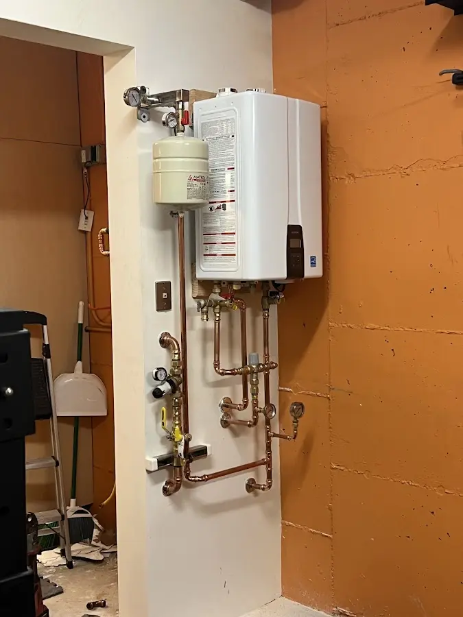 Plumbing technician inspecting water heater connections in Lakeville